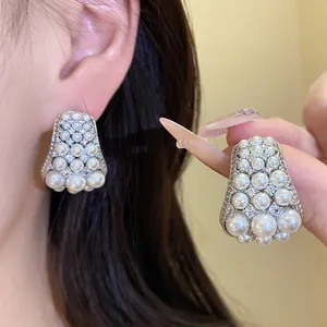 Nahaufnahme eleganter Trapez-Ohrstecker mit schimmernden Perlen und Zirkonia für Damen