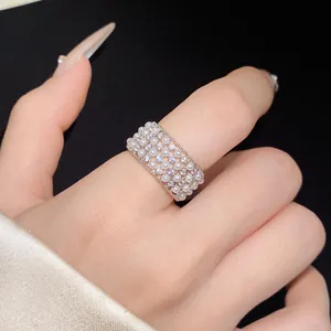Close-up detail of a wide zircon and pearl mesh open ring for women on finger