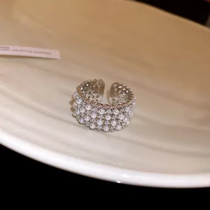Detailed macro view of a luxury adjustable open ring with pearls and sparkling zircons