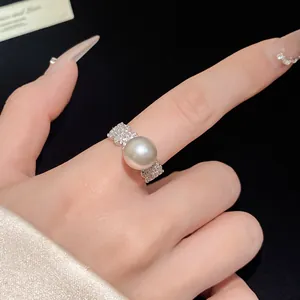 Close-up detail of an elegant zircon open ring with a large lustrous white pearl