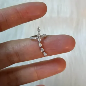 Detailed macro view of a minimalist silver earcuff featuring sparkling teardrop zircons on a finger