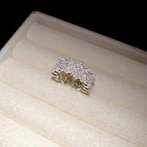 Close-up of elegant hollow open ring with delicate pearls and sparkling zircons