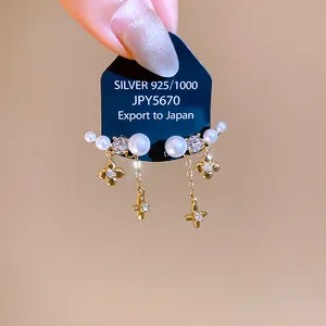 Primo piano di eleganti orecchini in argento S925 con perle bianche e stelle in zirconia