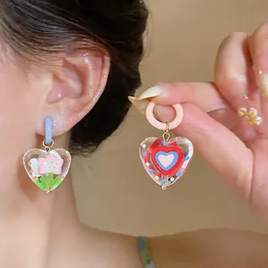 Close-up of vibrant colorful heart and flower pattern earrings in dopamine style
