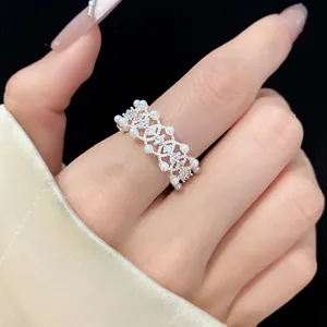 Close-up of an elegant silver-toned open ring featuring zircons and delicate pearls.