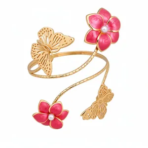 Elegant gold-tone wrap arm cuff featuring pink enamel flowers and butterfly motifs