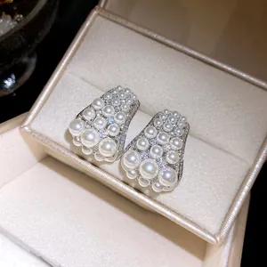 Detaillierte Nahaufnahme von eleganten Zirkon- und Perlenohrsteckern in einer Luxus-Geschenkbox