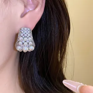 Nahaufnahme eleganter Silber-Ohrstecker mit abgestuften Perlen und funkelnden Zirkonia-Steinen