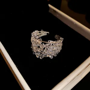 Detailed view of an elegant multi-layer open ring with sparkling clear zircon crystals