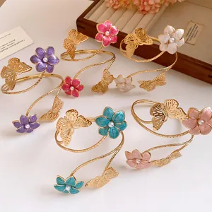 Detail of vintage metal arm cuffs with colorful enamel flowers and gold butterflies