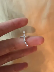 Detailed macro shot of a silver cross ear cuff set with clear sparkling zircons
