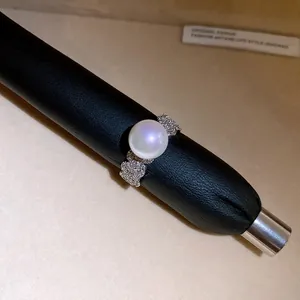 Detailed view of elegant open ring featuring a large pearl and sparkling zircon accents
