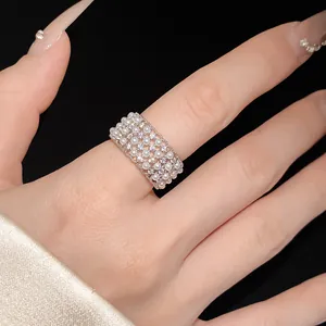 Exquisite close-up of a silver zircon and pearl ring on a finger with a detailed mesh design