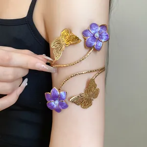 Elegant gold metal arm cuff featuring purple enamel flowers and butterfly detail on arm.