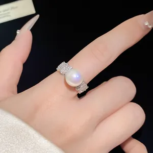 Detailed close-up showing the lustrous pearl and zircon pavé on a silver open ring