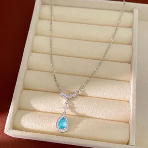 Elegant blue waterdrop and mermaid tail pendant necklace displayed in a beige jewelry box