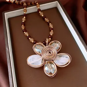 Detailed view of a vintage flower necklace with amber beads and wire-wrapped petals