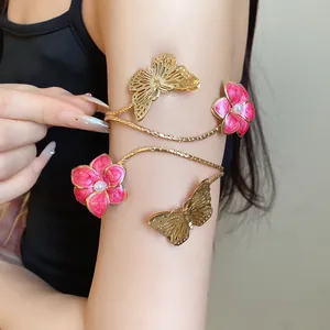 Detailed macro view of golden armlet featuring pink oil-dripped flowers and butterflies.