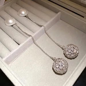 Elegant silver drop earrings featuring white pearls and rhinestone encrusted round balls