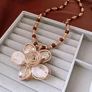 Detailed macro shot of vintage beaded flower necklace with crystal petals and gold wire wrap