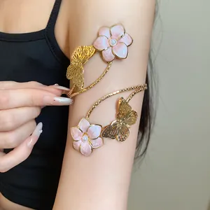 Close-up of a vintage golden armlet featuring pink enamel flowers and butterfly details