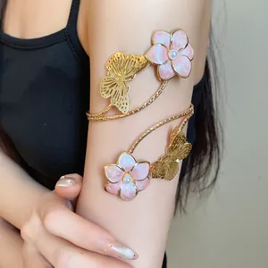Detailed view of a vintage metal arm cuff with pink enamel flowers and golden butterflies.