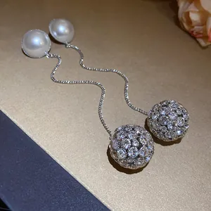 Detailed view of elegant silver drop earrings featuring pearls and sparkling crystal spheres