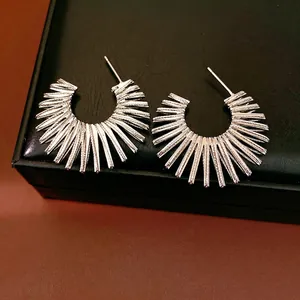 Elegant silver-colored sunburst C-shaped hoop earrings with a unique spiked avant-garde design