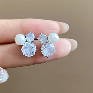 Close-up of elegant zircon and pearl earrings in a delicate floral Mickey silhouette