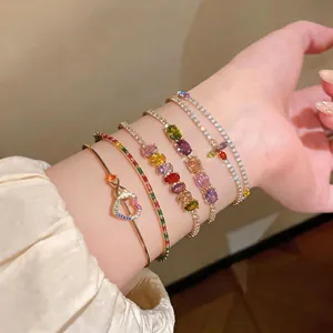Sparkling collection of colorful zircon bracelets and heart-shaped gold bangles