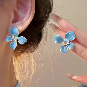 Detail view of sea salt blue flower stud earrings with a sparkling rhinestone center