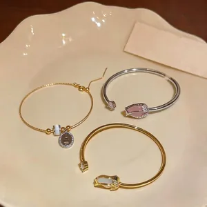 Elegant tulip open bangles with zircon and cat's eye stone on a ceramic plate