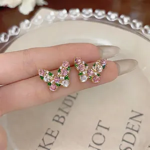Elegant butterfly stud earrings featuring pink and green zircons on gold-plated base.