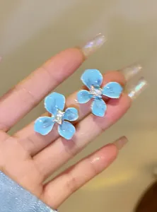 Detailed close-up of sea salt blue flower stud earrings with sparkling central crystals
