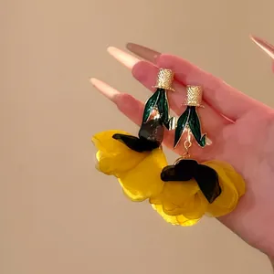 Détails exquis de boucles d'oreilles fleurs en mousseline jaune et accents dorés