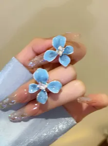 Detailed view of sea salt blue flower stud earrings with a central sparkling gem