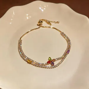 Close-up of elegant gold-plated tennis bracelet with colorful zircon flower motif
