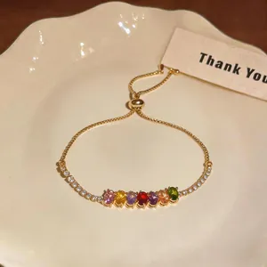 Detailed close-up of a gold-plated adjustable slider bracelet with vibrant multicolor zircon stones
