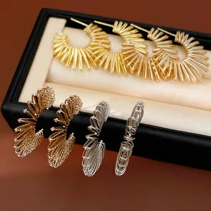 Close-up detail of geometric C-shaped hoop earrings in gold and silver finish