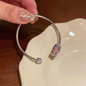 Detailed view of the pink cat's eye stone and clear zircon on a tulip open cuff bangle