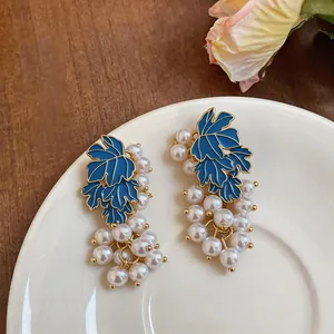 Detailed view of elegant blue enamel grape earrings featuring delicate white pearl clusters