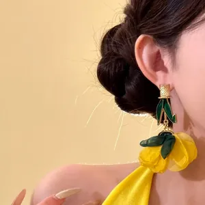 Gros plan détaillé de boucles d'oreilles fleurs jaunes surdimensionnées pour un look vacances