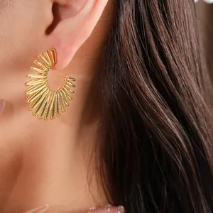 Detailed view of elegant gold-toned C-shaped pleated fan earrings worn by an Asian model