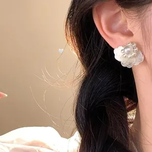 Elegante Perlenblumen-Ohrstecker an einem Model für einen sanften femininen Look