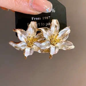 Retro white lily enamel stud earrings with golden edges and a vintage aesthetic