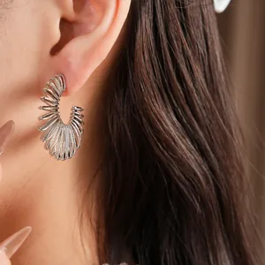 Detailed view of silver C-shaped wire hoop earrings with unique multi-layered design