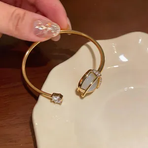 Detailed view of elegant golden tulip open cuff bracelet featuring cat-eye stone and zircon