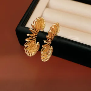 Detailed view of luxury gold-plated coiled C-shape hoop earrings on a black jewelry box