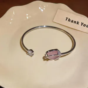 Detail of silver tulip bangle with pink cat's eye stone and sparkling zircons