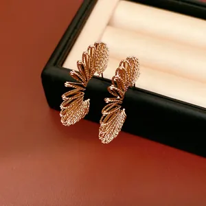 Close-up of elegant gold C-shaped spiral hoop earrings with a detailed textured finish